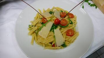 Een bord pasta met kerstomaatjes en kaas.
