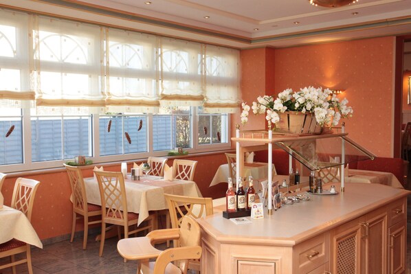 Un restaurant doté d’un bar, de chaises et de tables en bois. On peut voir des bouteilles sur le comptoir du bar.