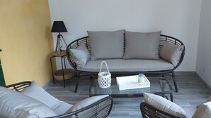 A balcony with a wicker sofa, two armchairs, a small table with a tray, a lamp, and a basket. - Gîte Le Suquet in the heart of Lambesc near the Pont Royal golf course (Lambesc)