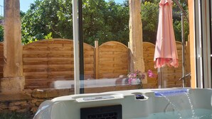A hot tub with a wooden fence and a pink towel hanging on a hook. - Gîte Le Suquet in the heart of Lambesc near the Pont Royal golf course (Lambesc)