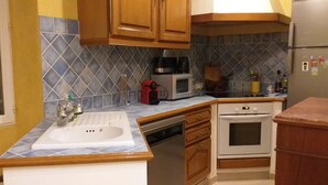 A kitchen with a sink, dishwasher, microwave, and oven. - Gîte Le Suquet in the heart of Lambesc near the Pont Royal golf course (Lambesc)