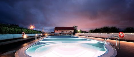 Una piscina al aire libre de temporada, sombrillas