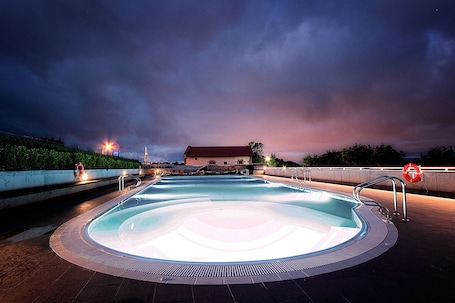 Una piscina al aire libre de temporada, sombrillas