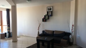 A modern living room with a sofa, coffee table, and decorative vases. - Sea Breeze Pomorie (Pomorie)