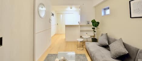 Una sala de estar moderna con un sofá gris, una mesa de centro y una planta.