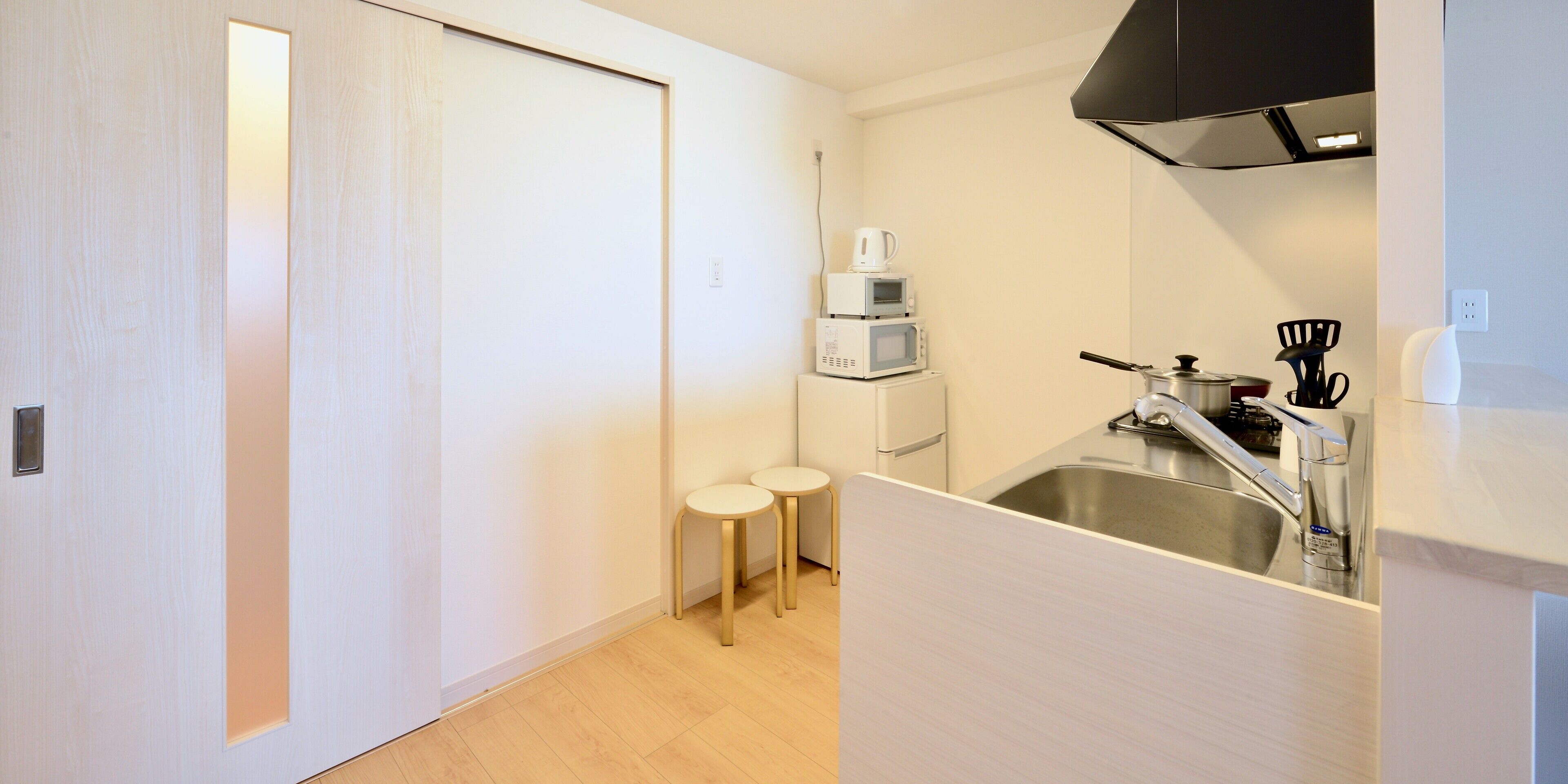 A compact kitchen with a microwave, coffee maker, and sink.