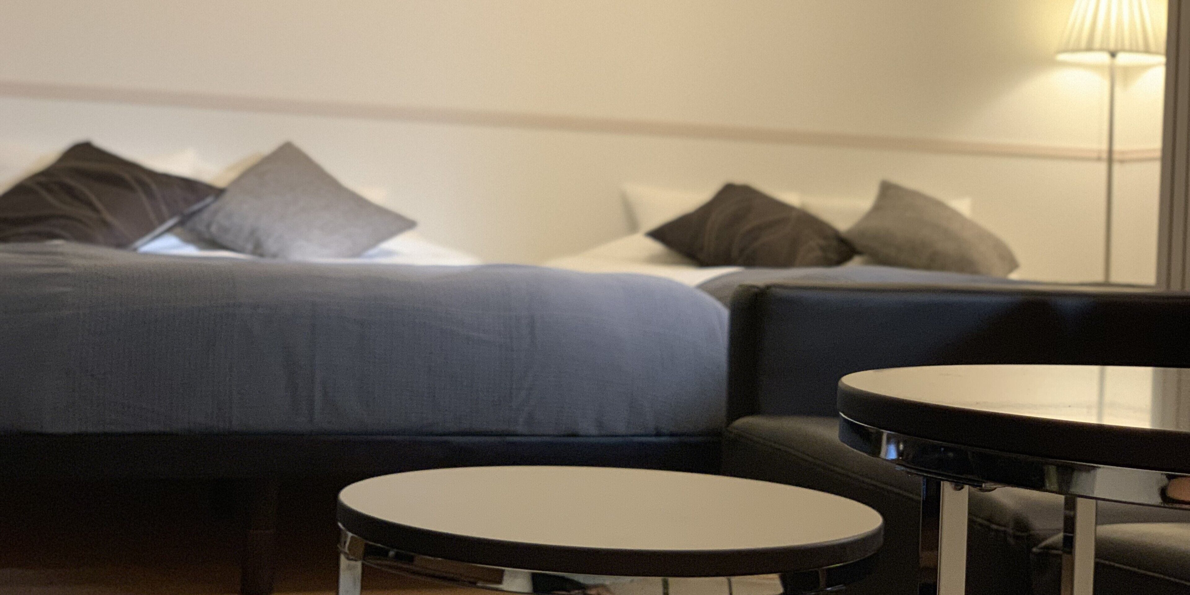 Une chambre d’hôtel avec un lit, une petite table ronde et un canapé.