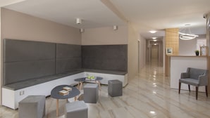 Una sala moderna con un sofá modular, una mesa de centro y un rincón de descanso.