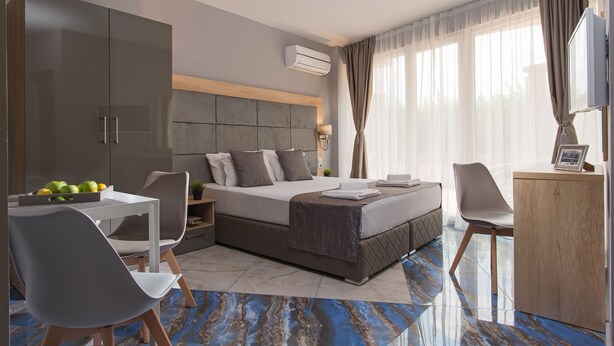 Una habitación de hotel moderna con una cama grande, un escritorio y un área de comedor.