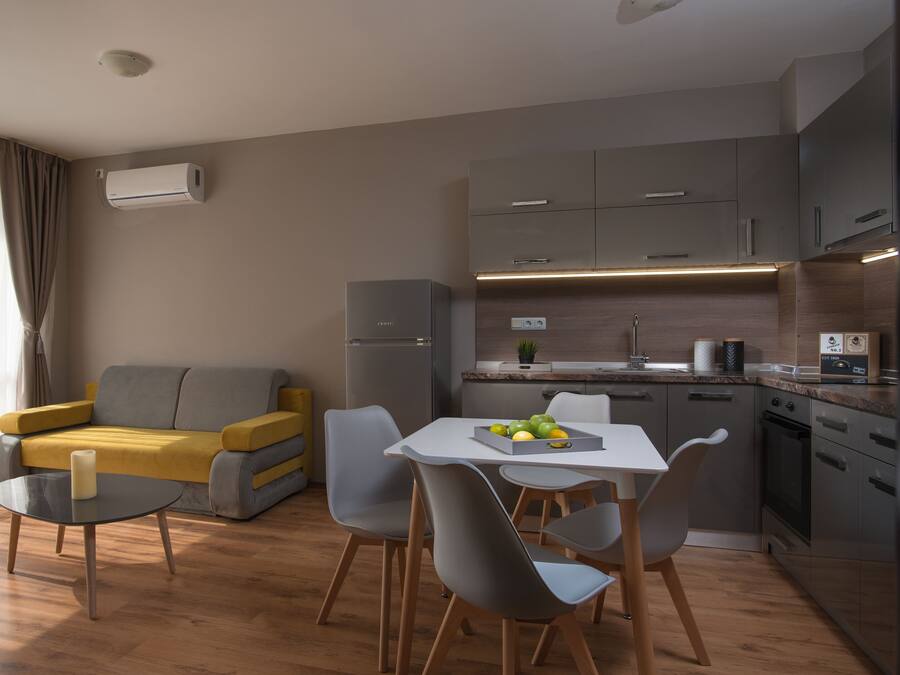 A modern apartment with a dining area, kitchen, and living space.