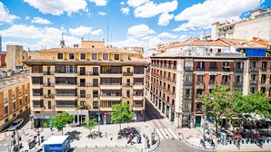 Un immeuble à plusieurs étages doté de balcons, une zone piétonne et un ciel dégagé.