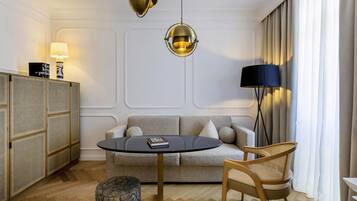A modern living room with a sofa, round table, and two chairs.