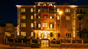 Un hôtel à plusieurs étages, avec des fenêtres illuminées et une entrée bien éclairée.