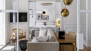 Une chambre d’hôtel moderne avec un canapé, une table à manger et un lit donnant sur une vue agréable.
