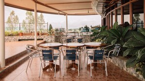 An outdoor patio area with tables and chairs, overlooking a scenic view. - Hotel La Maria (Guiuan)