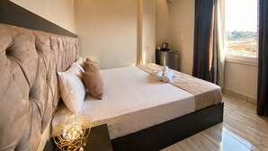 A modern hotel room with a large bed, a bedside table, an air conditioning unit, and a window with a view. - Tut Pyramids View Hotel (Giza)