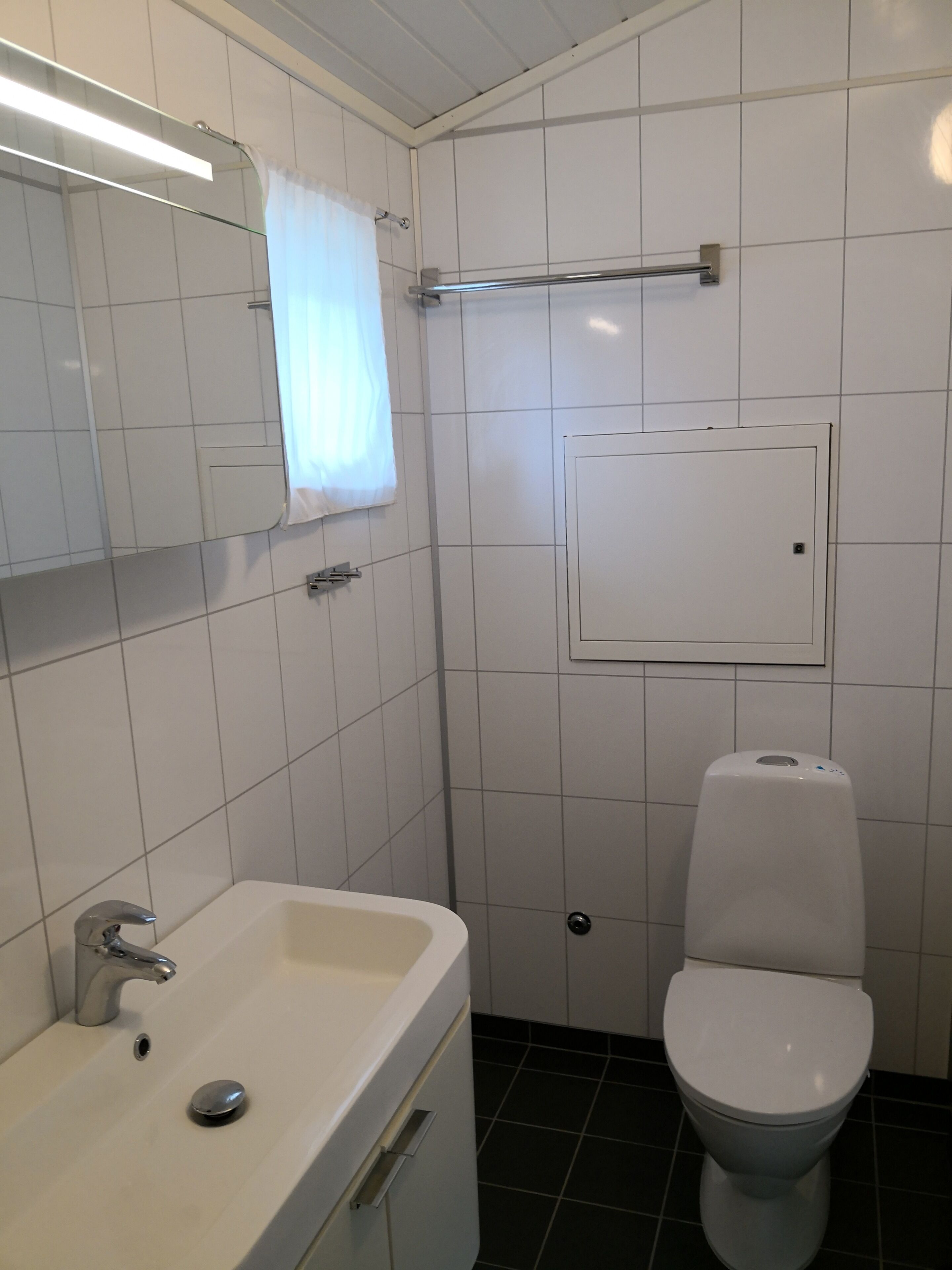 Ein Badezimmer mit Waschbecken, Spiegel und Toilette.