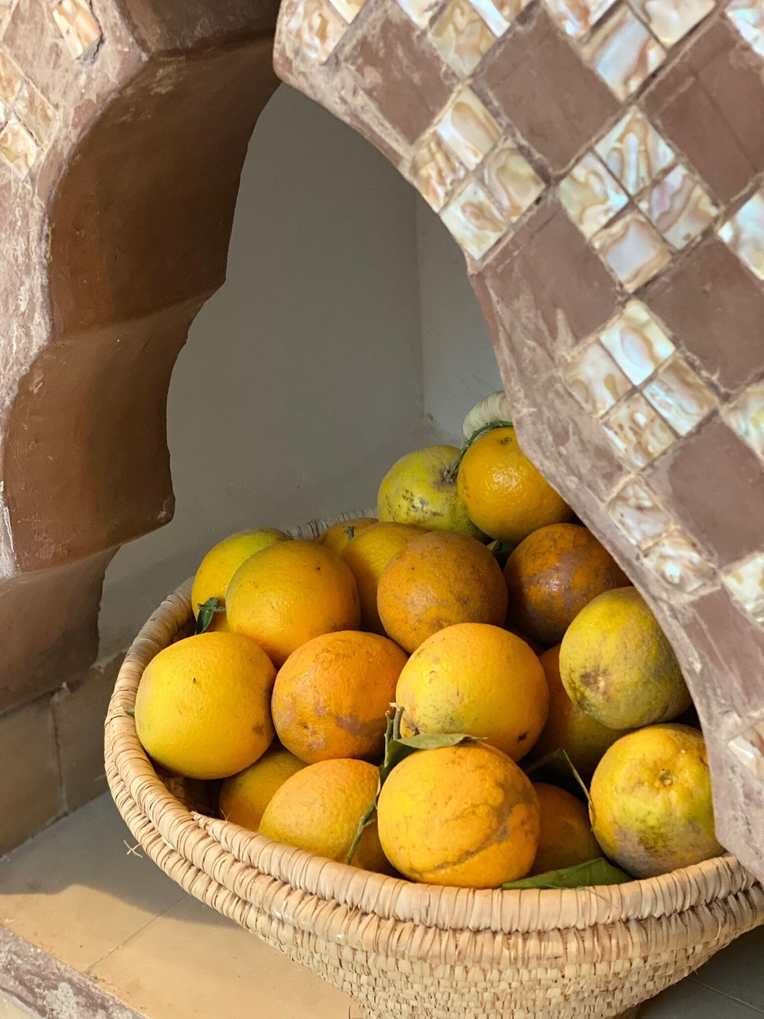 A basket of lemons and limes in a woven basket.