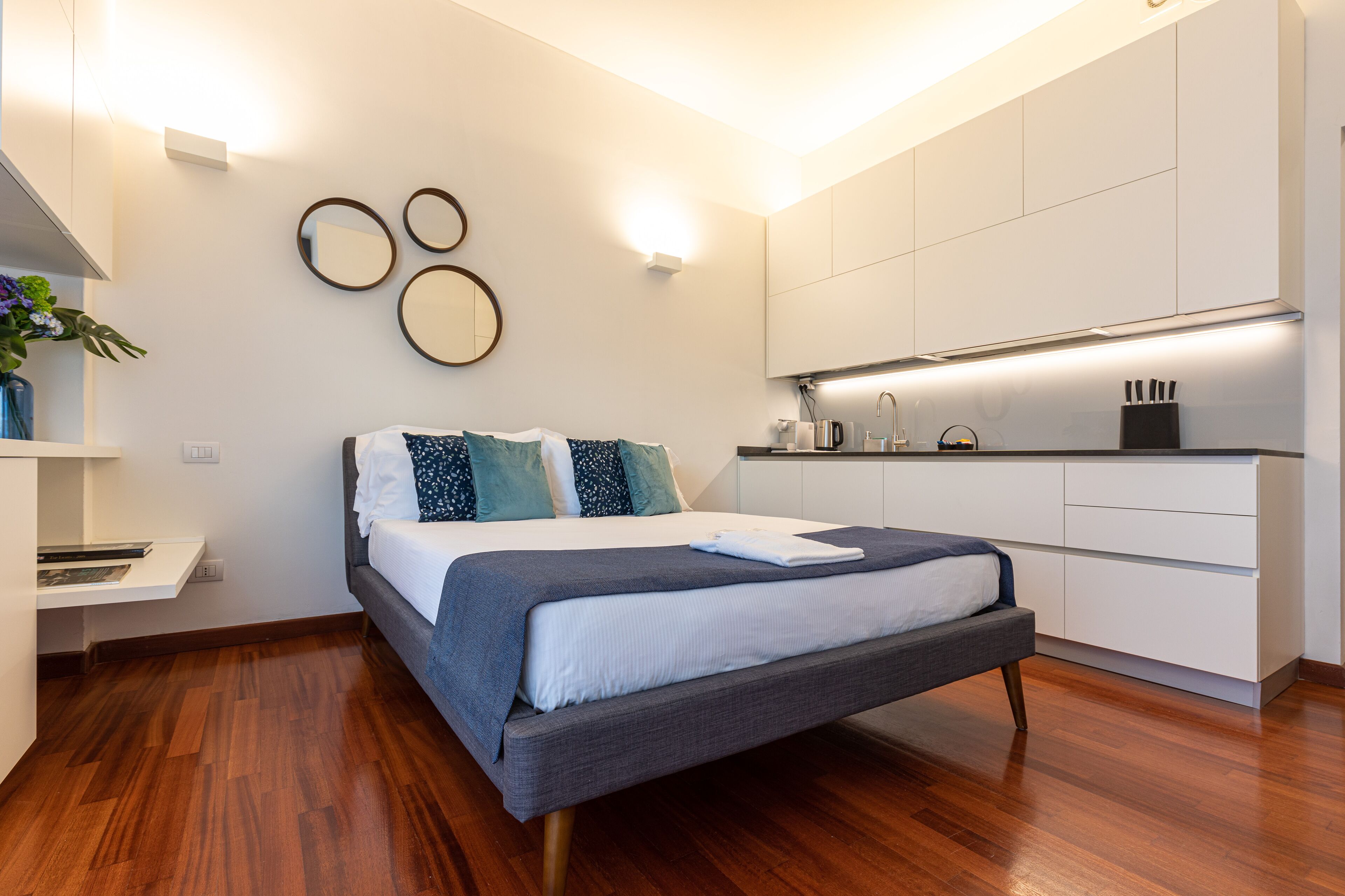 Une chambre à coucher moderne avec un lit, des tables de chevet et une armoire intégrée.