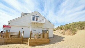 A white building with a balcony and a wooden fence. -  Sandunes 2    (Camber)
