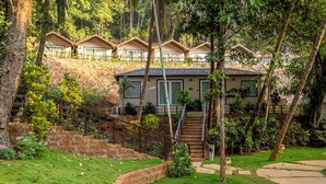 Ein Resort mit mehreren Bungalow-Unterkünften, einer zentralen Treppe und einem gepflegten Garten.