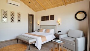 Ein modernes Schlafzimmer mit einem großen Bett, einer Couch, einem kleinen Tisch und Wanddekoration.