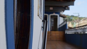 A corridor with a blue wall and a wooden door. - Hotel Zibamba (São Francisco do Sul)