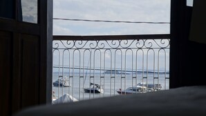 A balcony with a metal railing overlooking a body of water with boats. - Hotel Zibamba (São Francisco do Sul)