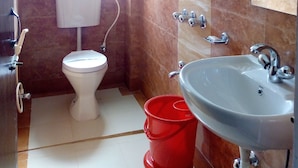 A bathroom with a toilet, sink, and shower. - Hotel Niladrii Galaxy (Siliguri)