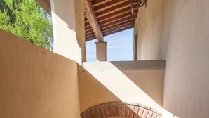 Una escalera que conduce a un espacio cubierto con una planta en maceta y una ventana.
