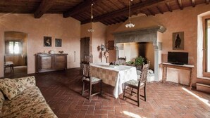 Un interior rústico con comedor, techo de madera y chimenea.