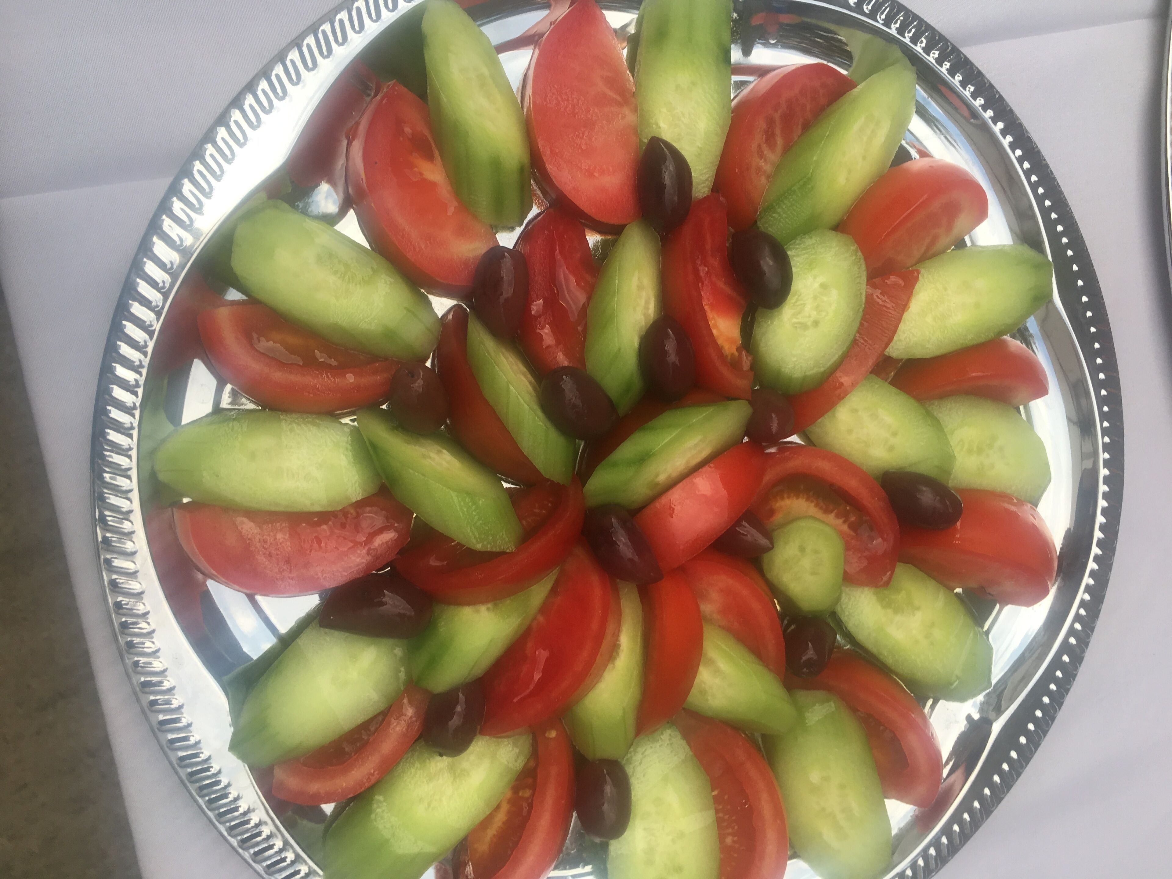 A plate of sliced vegetables arranged in a circular pattern.
