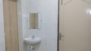 Un baño con lavamanos, espejo y puerta.