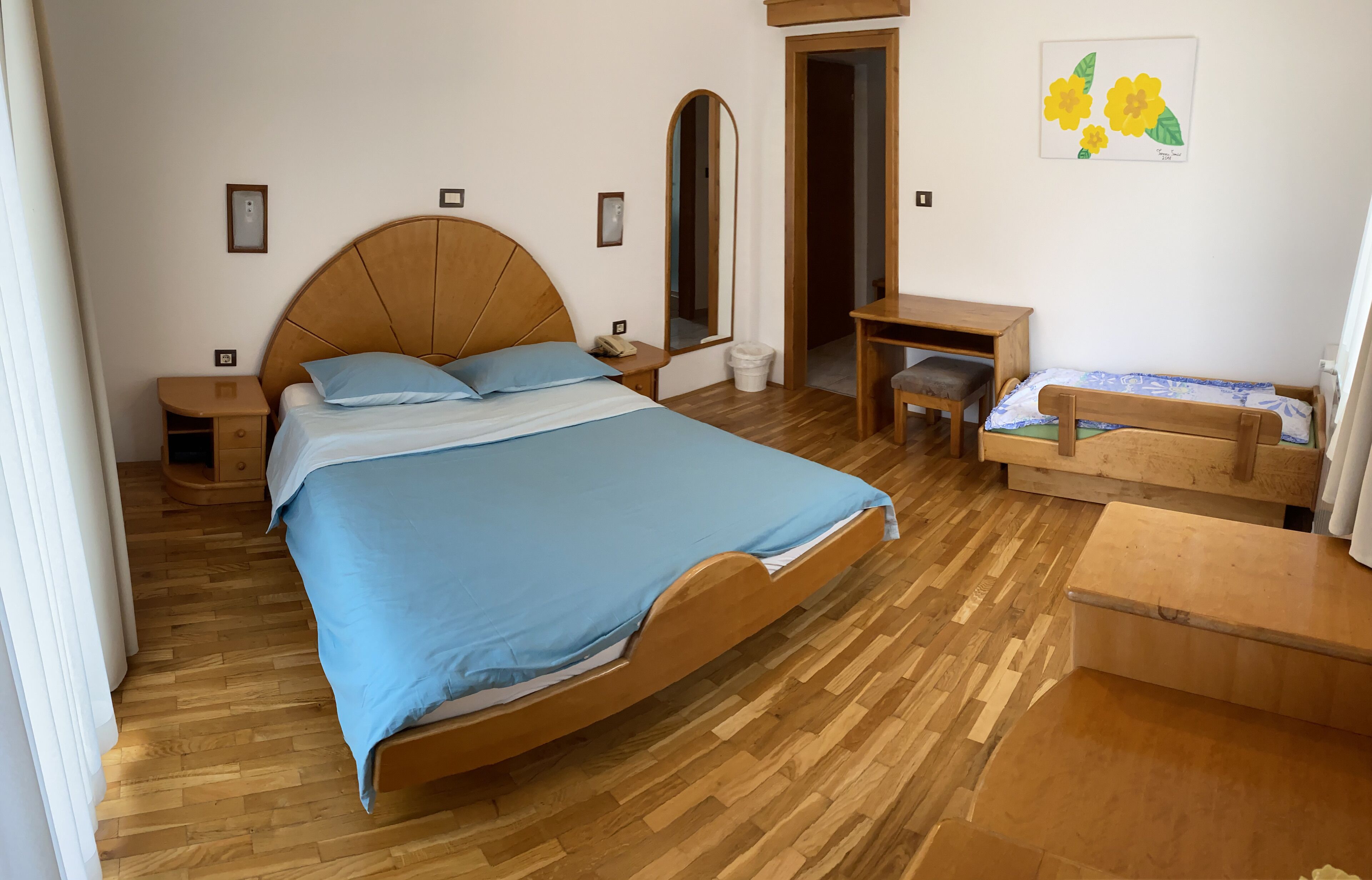 Un dormitorio con una cama de madera, un escritorio y una silla.