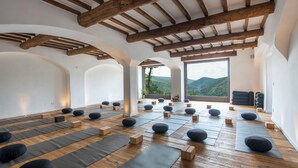 A yoga studio with wooden beams, tatami mats, and black yoga balls. - Eremito (Parrano)