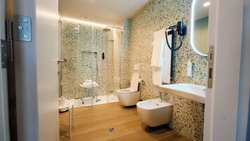 Un baño moderno con ducha, inodoro, bidé y lavabo.