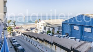 Ein Hotel an der Küste mit Blick auf den Strand, einem Parkplatz und einem blauen Gebäude mit vergitterten Fenstern.