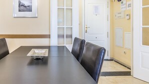 Ein Konferenzraum mit dunklem Tisch, Ledersesseln, einem gerahmten Bild an der Wand und einer Tür zu einem anderen Raum.