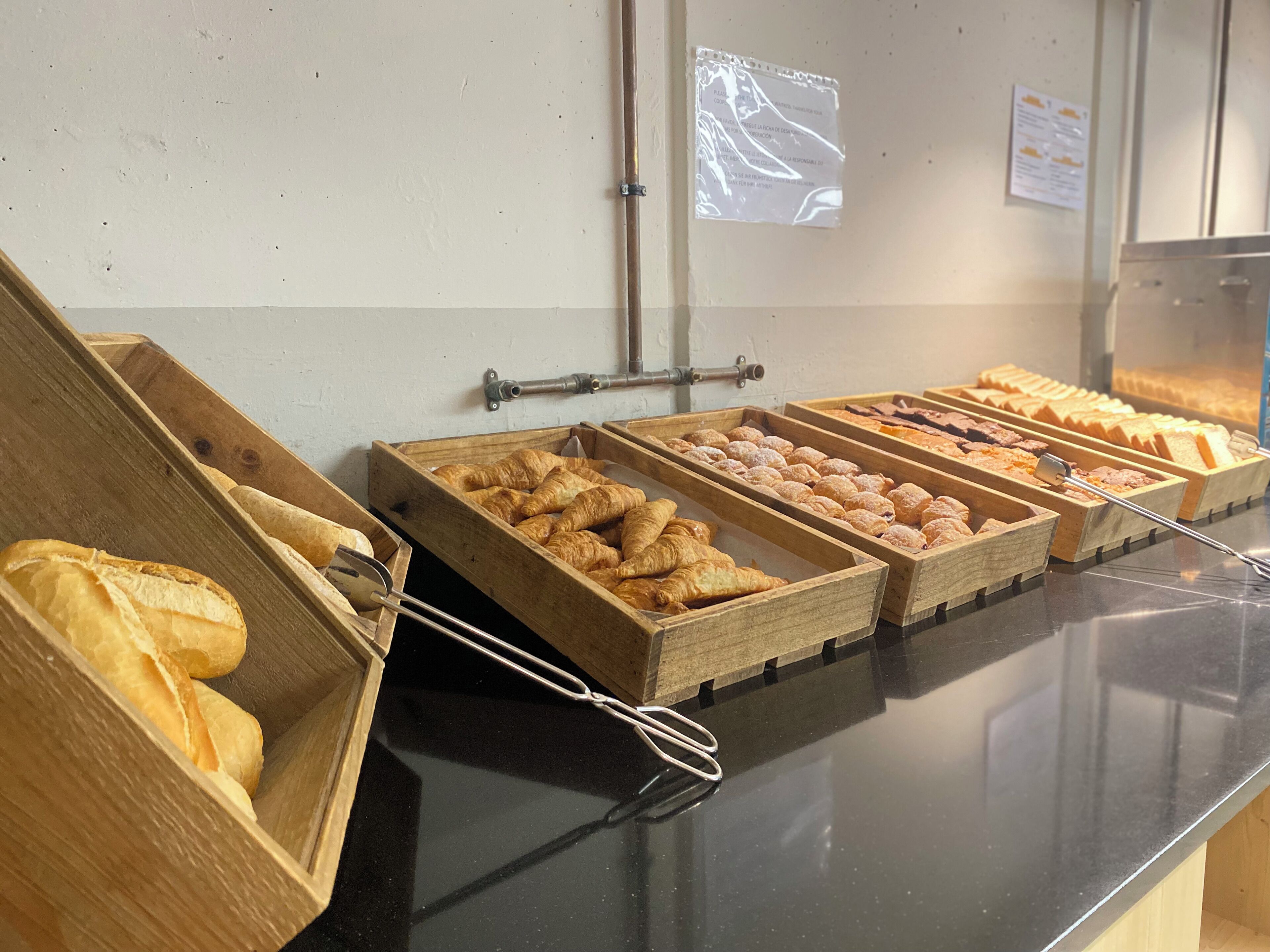A buffet with various baked goods displayed in wooden trays.
