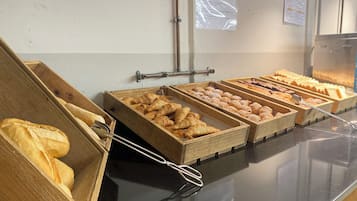 A buffet with various baked goods displayed in wooden trays.
