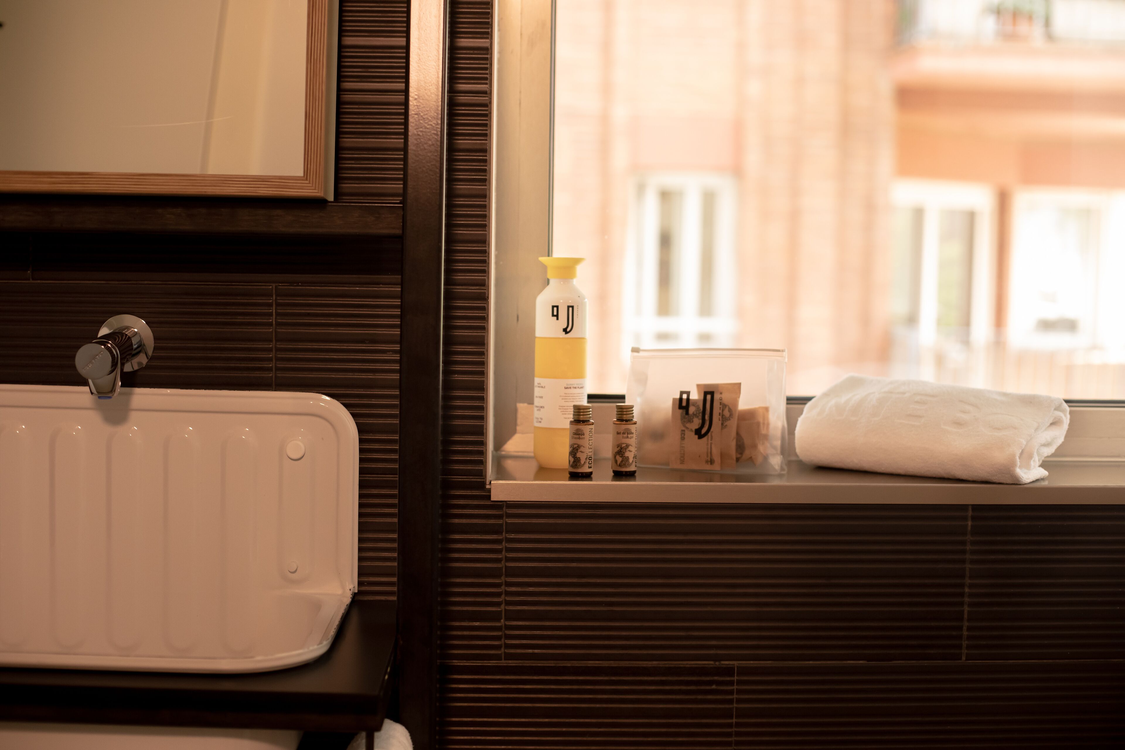 A bathroom with a white sink, a mirror, and toiletries on a counter.