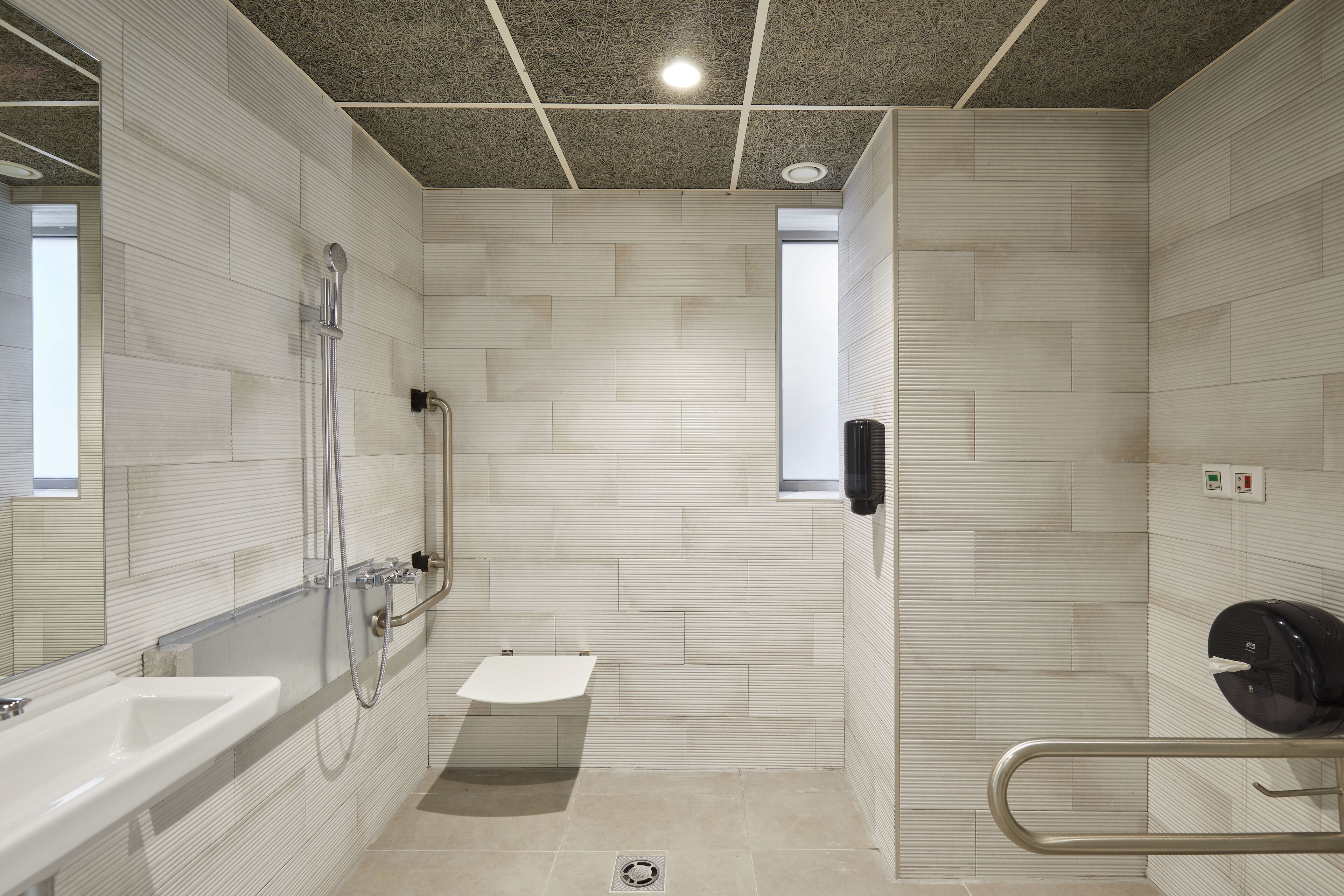 Ein modernes Badezimmer mit barrierefreier Dusche, Waschbecken und Toilette.