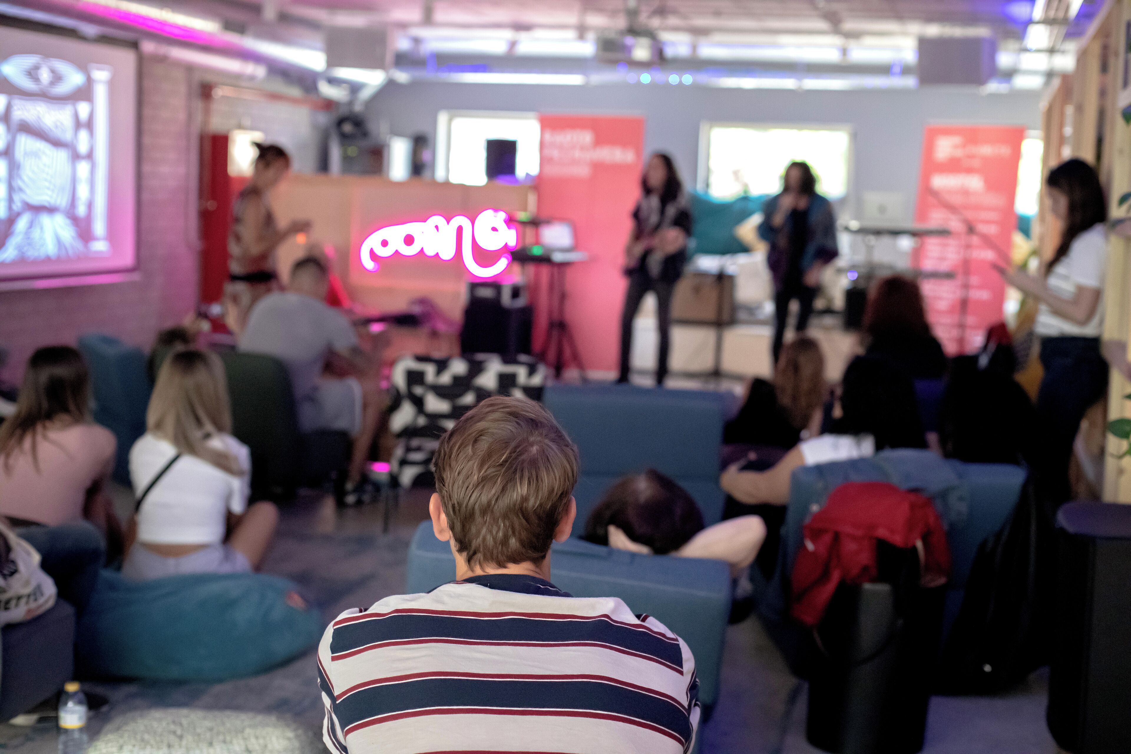 A modern indoor space with a stage and seating area, likely for presentations or events.