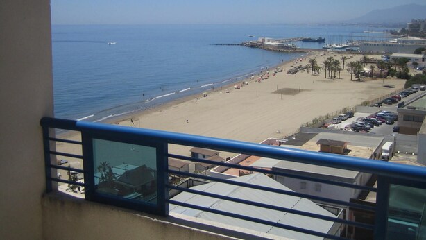 A beach with a marina, clear blue sky, and a view of the ocean. - Frontal sea views penthouse (Marbella)