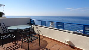 A terrace with a table and chairs, overlooking the sea. - Frontal sea views penthouse (Marbella)