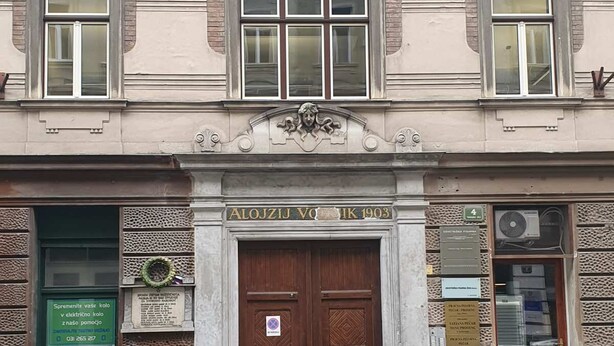 Un bâtiment doté d’une entrée centrale, d’une enseigne au-dessus de la porte et d’une plaque au-dessus des fenêtres.