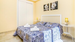 A hotel room with a bed, a bedside table, a lamp, and two wall-mounted paintings. - Magnifico apartamento en Marbella con vistas al mar (Marbella)