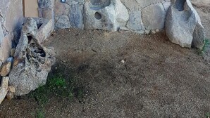 Un muro de piedra con una ventana pequeña y una puerta.