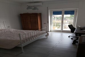 A bedroom with a bed, a wardrobe, a desk, and a chair.