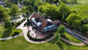 A large, two-story house with a spacious patio and a covered outdoor seating area. - Hotel Reindahls (Altlandsberg)